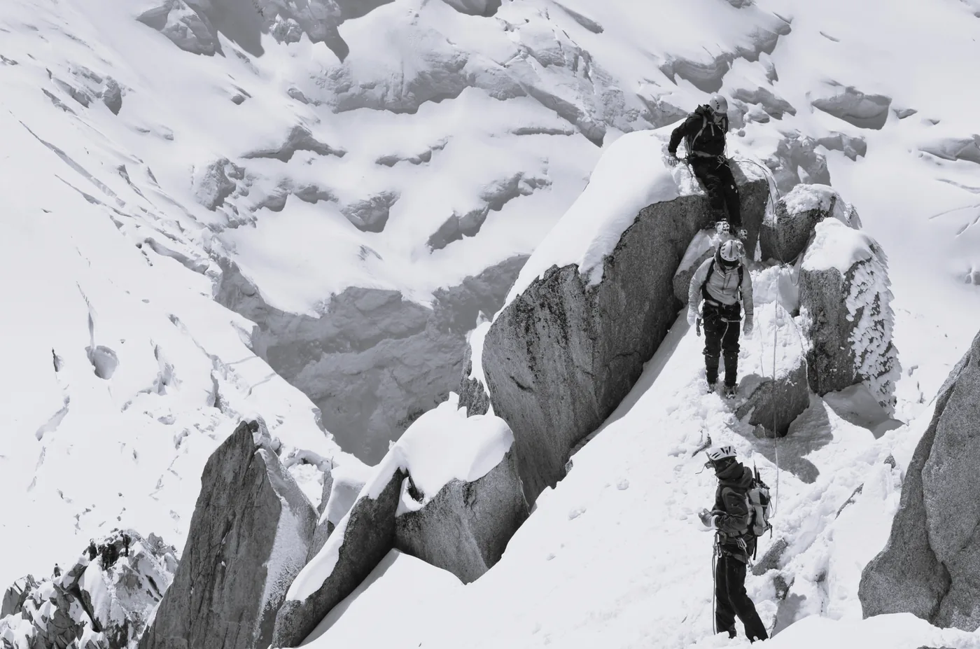 Roped team of climbers moving together on a snow ridge